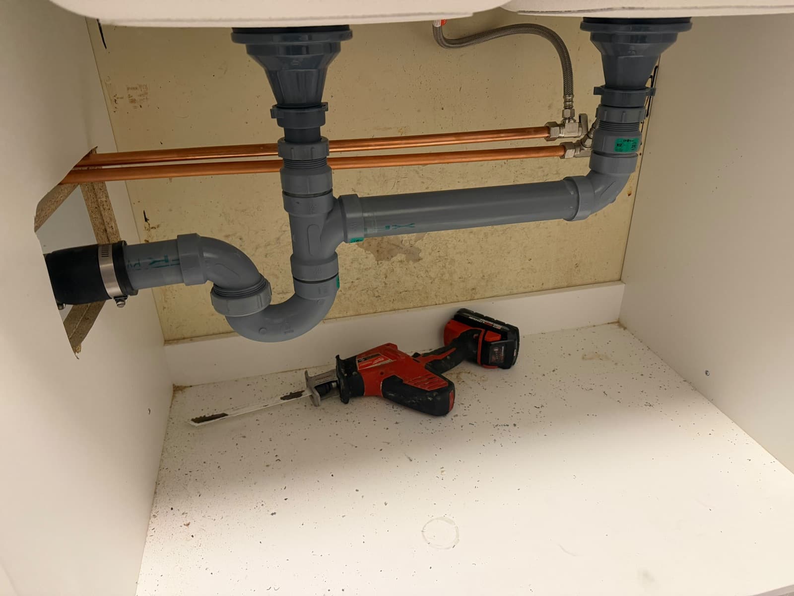 New drain lines and copper supply lines under a double kitchen sink